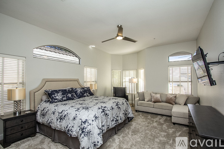 A bedroom with a large bed and a couch.