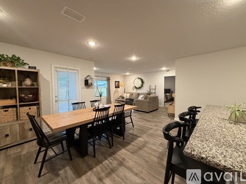 A dining room with a wooden table and chairs.