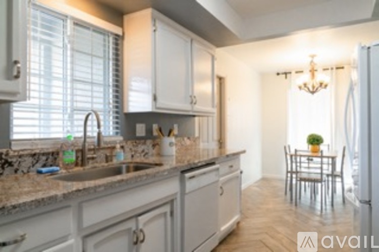 A kitchen with granite countertops and a dining table.
