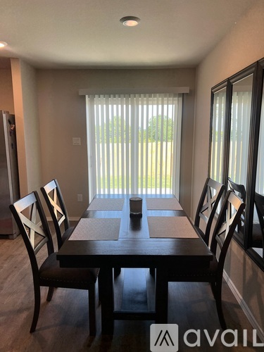 A dining room with a table and chairs.