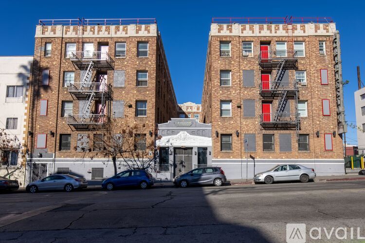 Two red fire escapes on the side of a building.