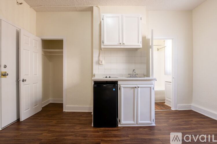 A kitchen with white cabinets and a black dishwasher.