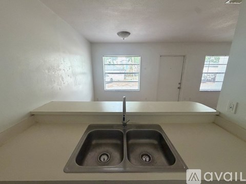 A kitchen with a double sink and a window.