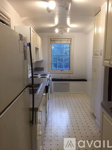A kitchen with white cabinets and a black stove top oven.