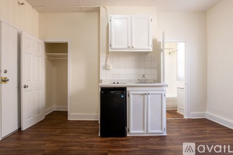 A kitchen with white cabinets and a black dishwasher.