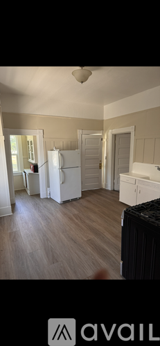 A kitchen with a white refrigerator and wooden floors.