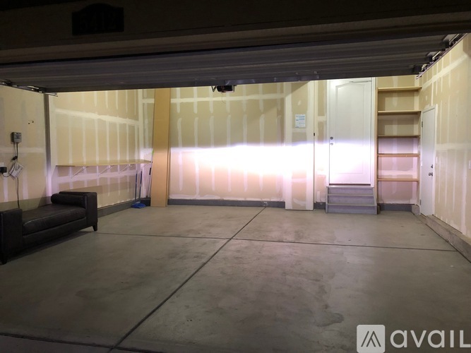 A large, empty room with a concrete floor and white walls.