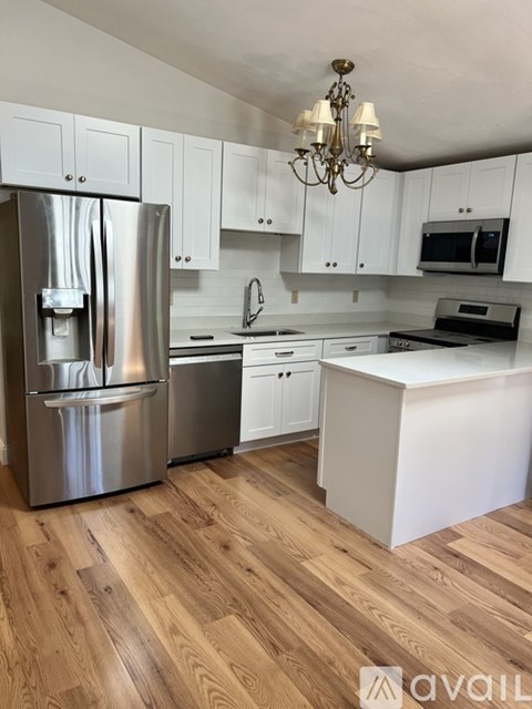 A kitchen with a refrigerator, stove, and cabinets.
