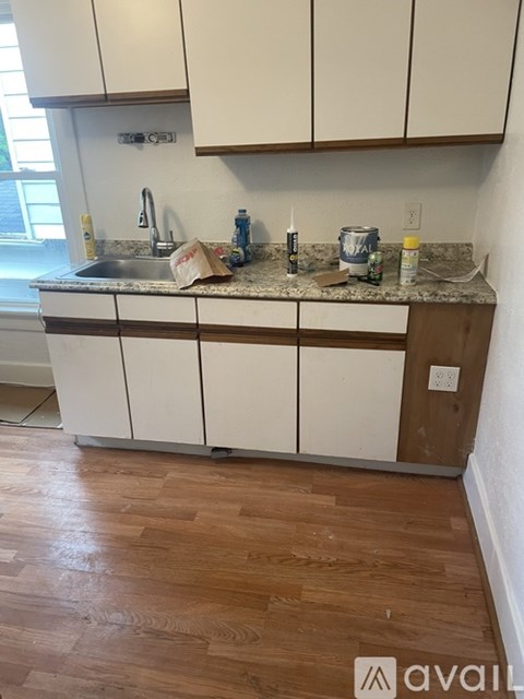 A kitchen with white cabinets and a granite countertop.