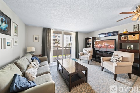 A living room with a couch, chair, and television.