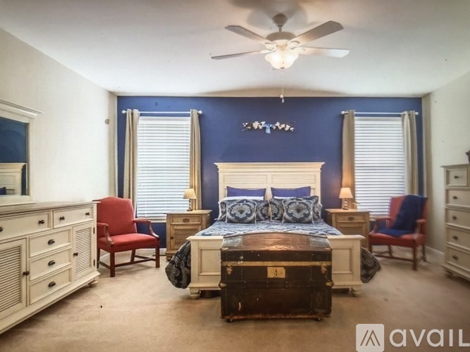 A bedroom with a bed, dresser, and chair.