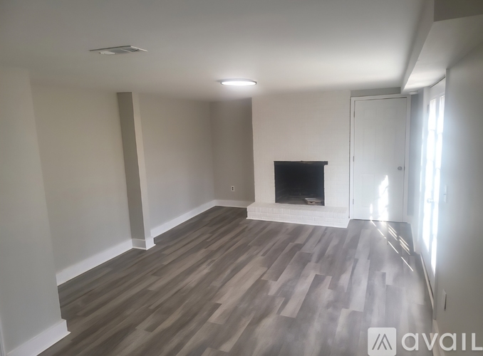 A living room with a fireplace and wood flooring.