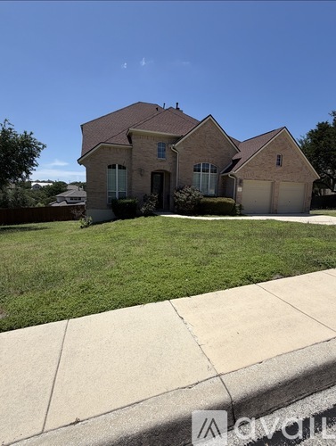A house with a brown roof and a green lawn in front.