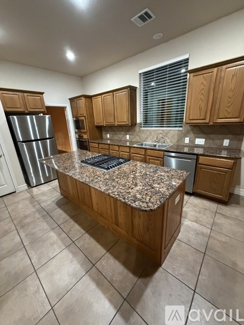 A kitchen with wooden cabinets and granite countertops.
