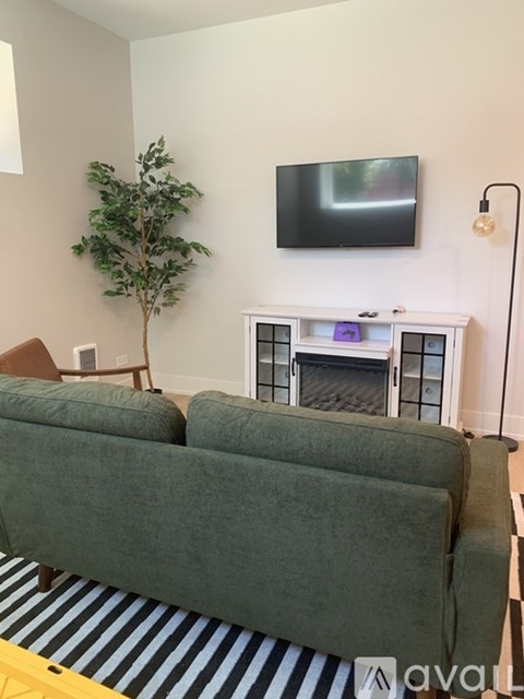 A living room with a green couch and a fireplace.