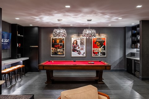 A room with a pool table and a bar.