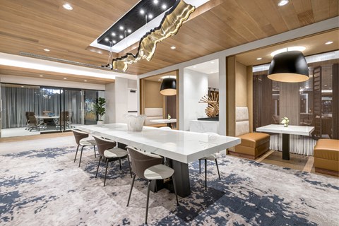 A modern dining room with a long table and chairs.