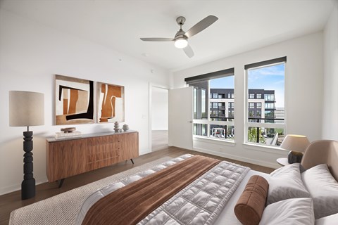 A bedroom with a large bed and a window overlooking a building.