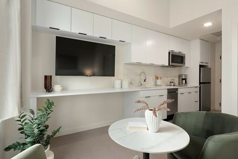 A modern kitchen with a green chair and a white table.