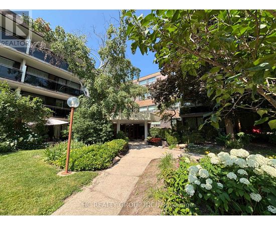 A garden pathway leads to a building with a sign that reads "REALTOR".