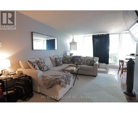 A living room with a white couch and a large window.