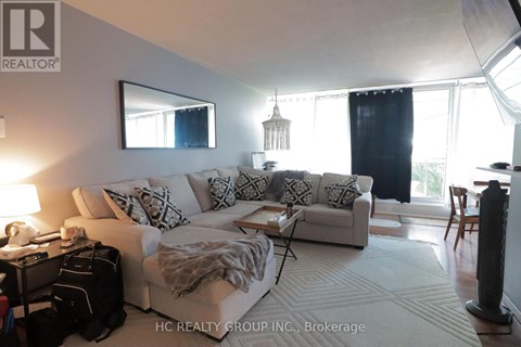 A living room with a white couch and a large window.