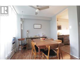 A dining room with a wooden table and chairs.