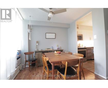 A dining room with a wooden table and chairs.