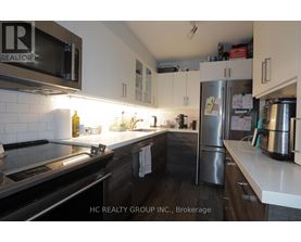 A kitchen with a stove, microwave, and refrigerator.