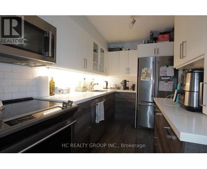 A kitchen with a stove, microwave, and refrigerator.