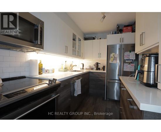 A kitchen with a stove, microwave, and refrigerator.