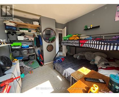 A small bedroom with a bed, a desk, and a bunk bed.