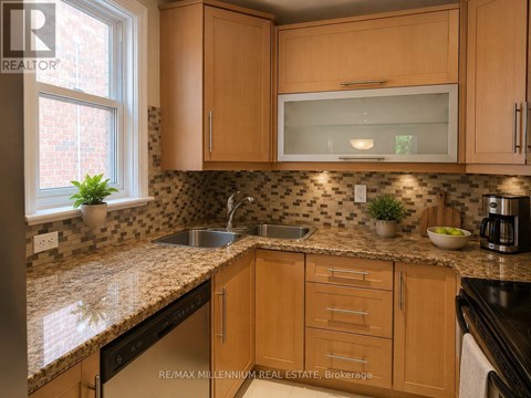 A kitchen with wooden cabinets and a granite countertop.