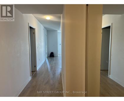 A hallway with a dog sitting on the floor.