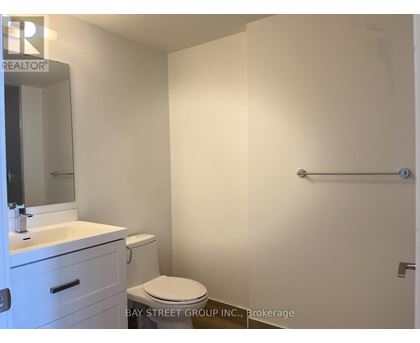 A white bathroom with a toilet, sink, and mirror.