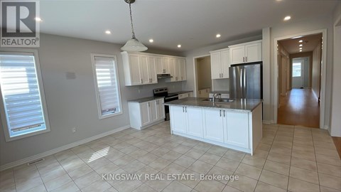 A spacious kitchen with white cabinets and a central island.