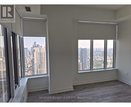 A room with a view of the cityscape through large windows.