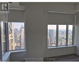 A room with a view of the cityscape through large windows.