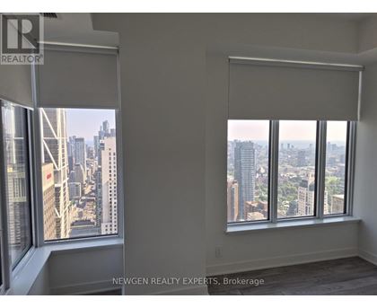 A room with a view of the cityscape through large windows.