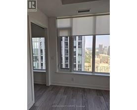 A room with a view of the city through large windows.