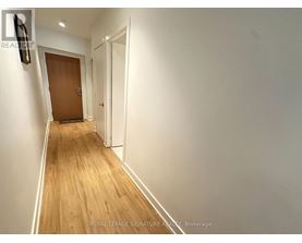 A hallway with a wooden floor and white walls.