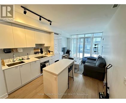A well-lit kitchen with white cabinets and a wooden island.