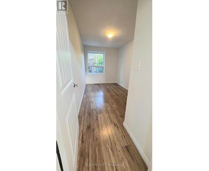 A hallway with wooden floors and white walls.