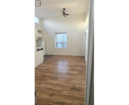 A room with wooden flooring and a window.