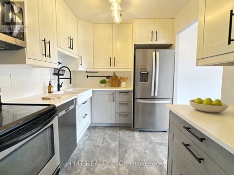 A kitchen with white cabinets and a stainless steel refrigerator.