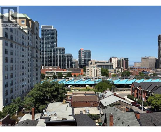 A cityscape with buildings of various heights and a clear blue sky.