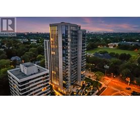 A tall building with the word REALTOR on it is lit up at dusk.