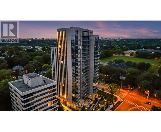 A tall building with the word REALTOR on it is lit up at dusk.