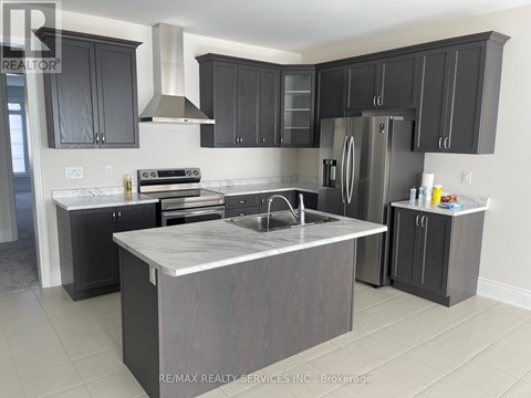 A modern kitchen with dark grey cabinets and a central island.