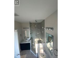 A bathroom with a walk in shower and a sink.